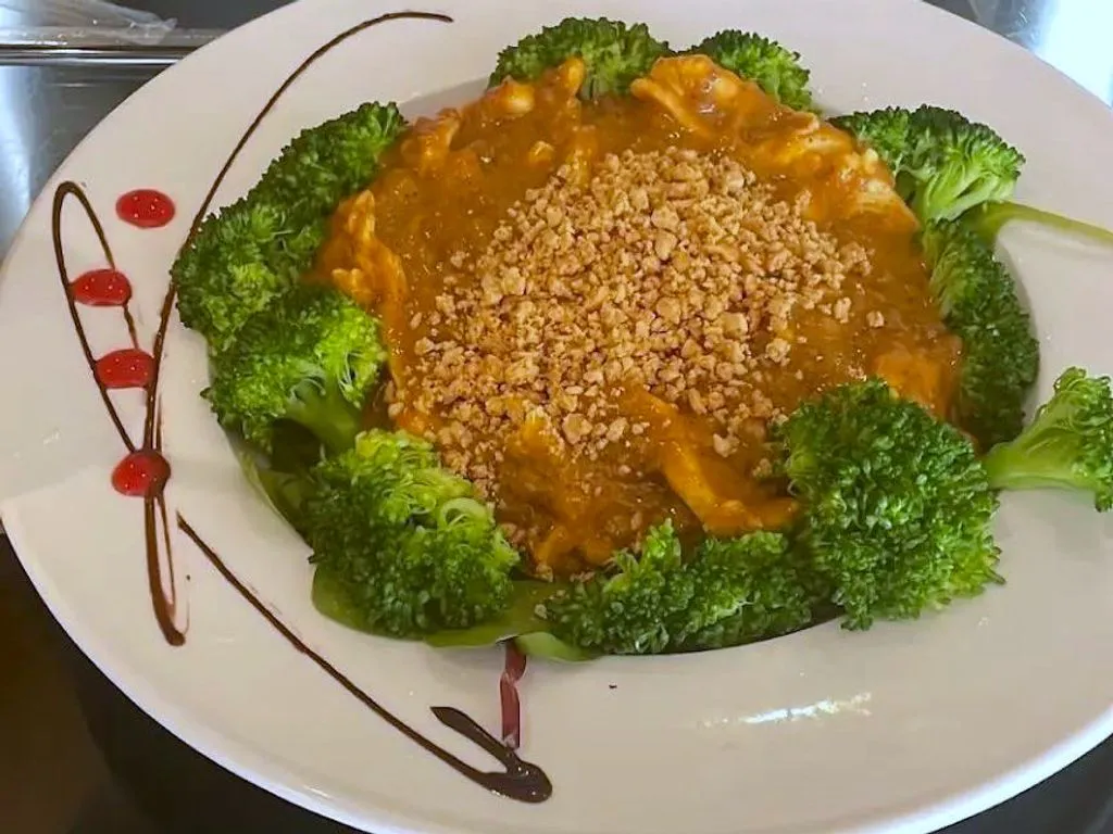 Peanut-topped curry dish with fresh broccoli florets arranged decoratively at Green Papaya Thai Cuisine, a Thai Restaurant in Jacksonville